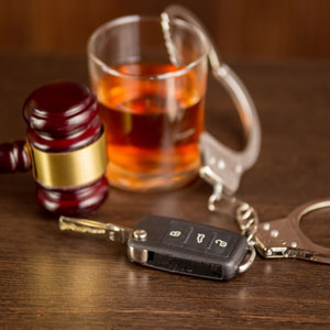 Image of car key, handcuffs, gavel and alcohol glass representing DUI consequences